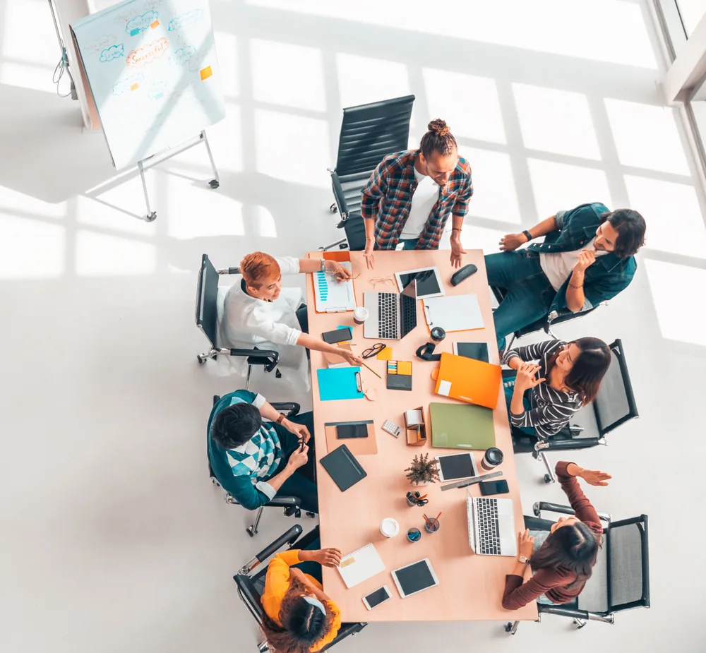 Workshop-Situation: Team arbeitet gemeinsam am Tisch mit Flipchart